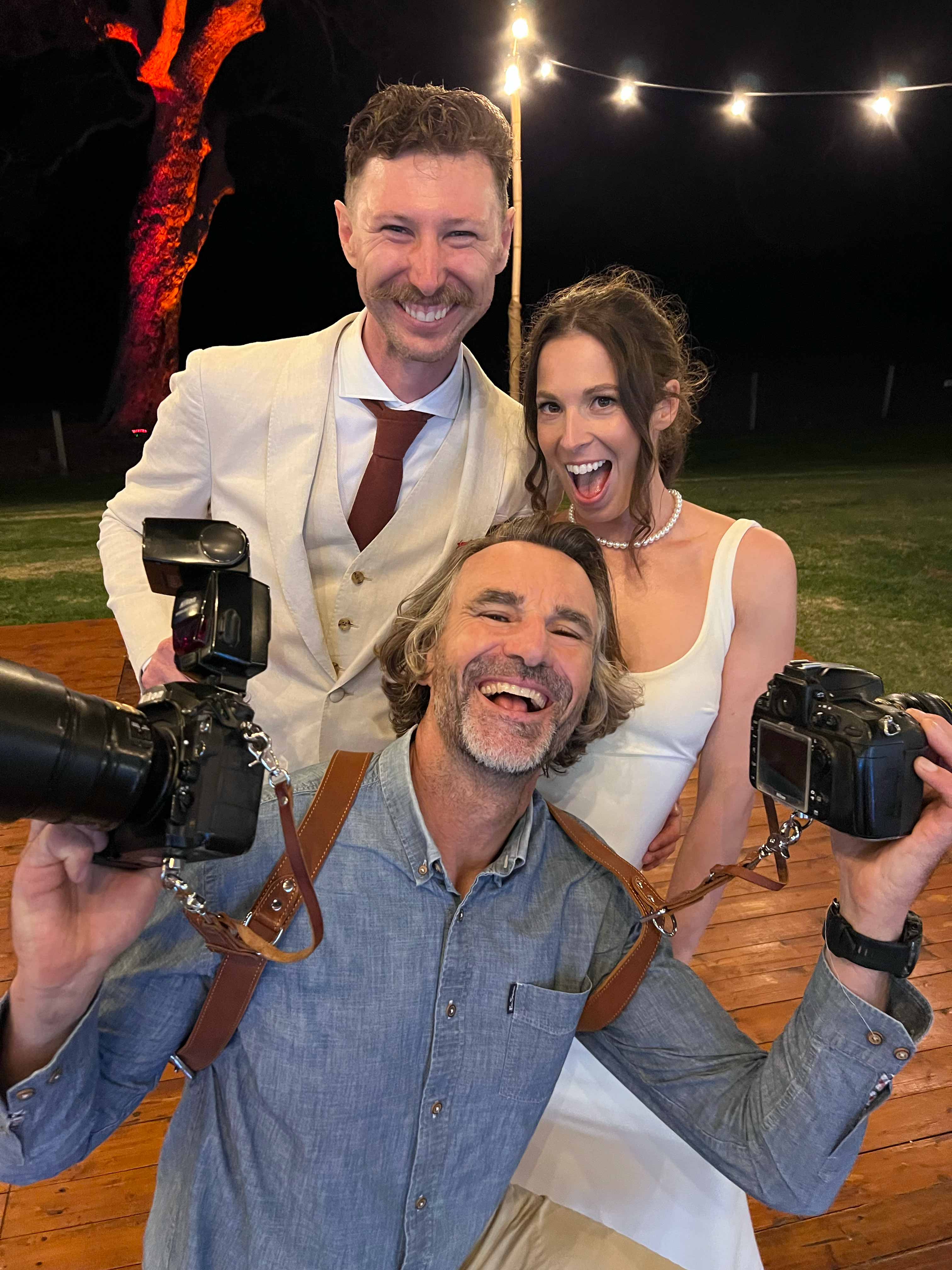 fun photo of john rice interacting with very happy bride and groom
